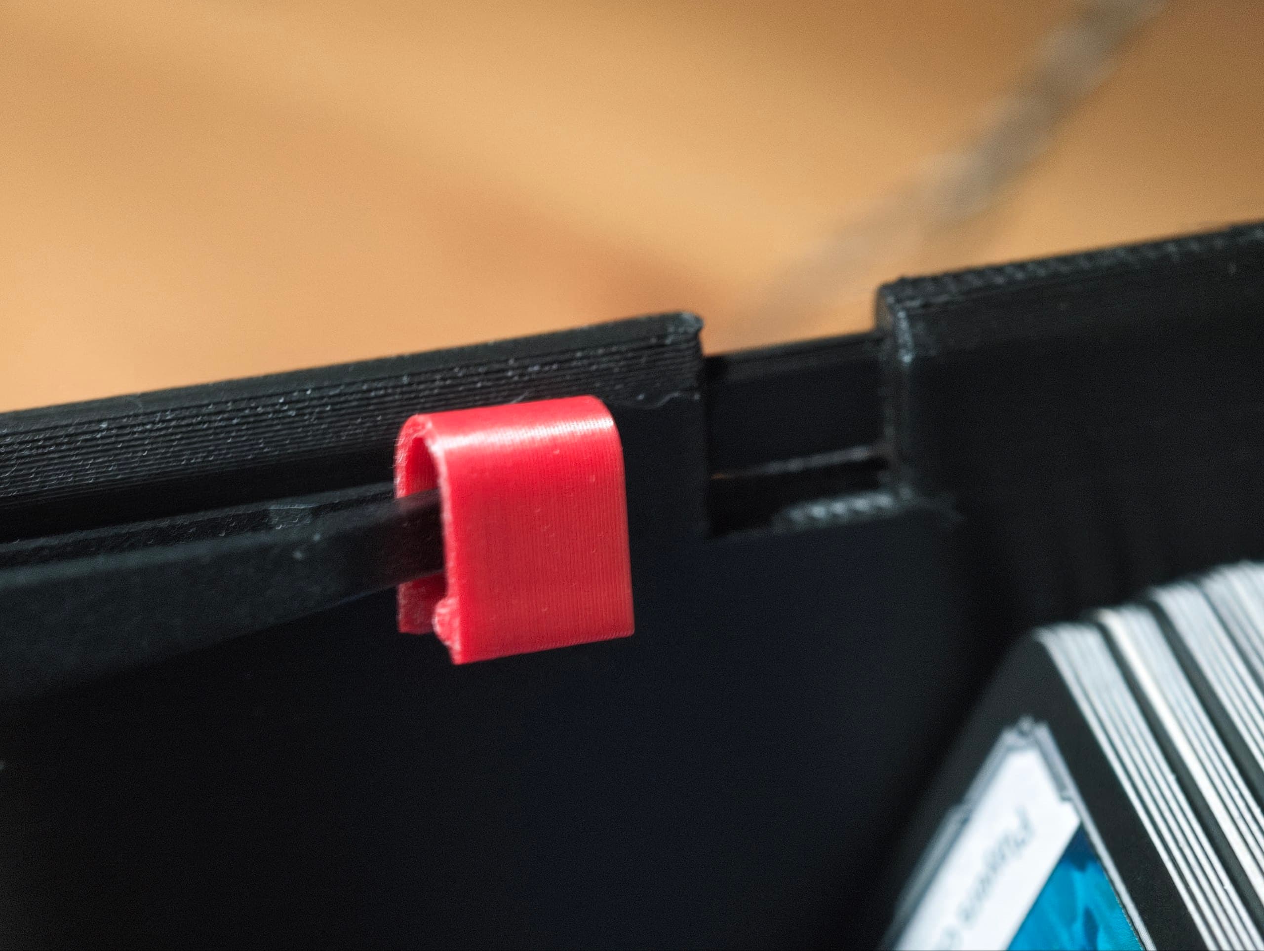 Close-up of a red snap-in color tab clipped onto a lane divider